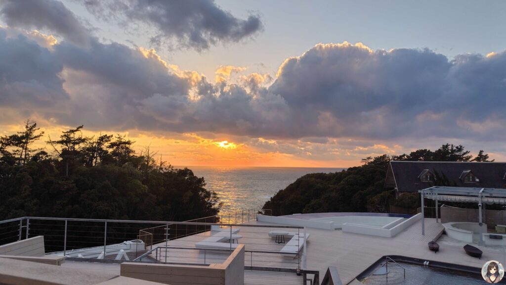 水平線に沈む夕日と水面に映る夕焼け